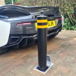 telescopic bollard behind black sports car
